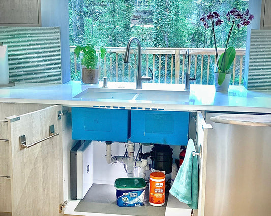 Photo of the Undersink Ultrafiltration System installed in the cabinet under a kitchen sink. Image highlights the space saving design and small footprint. There is still lots of extra storage space left in the cabinet.