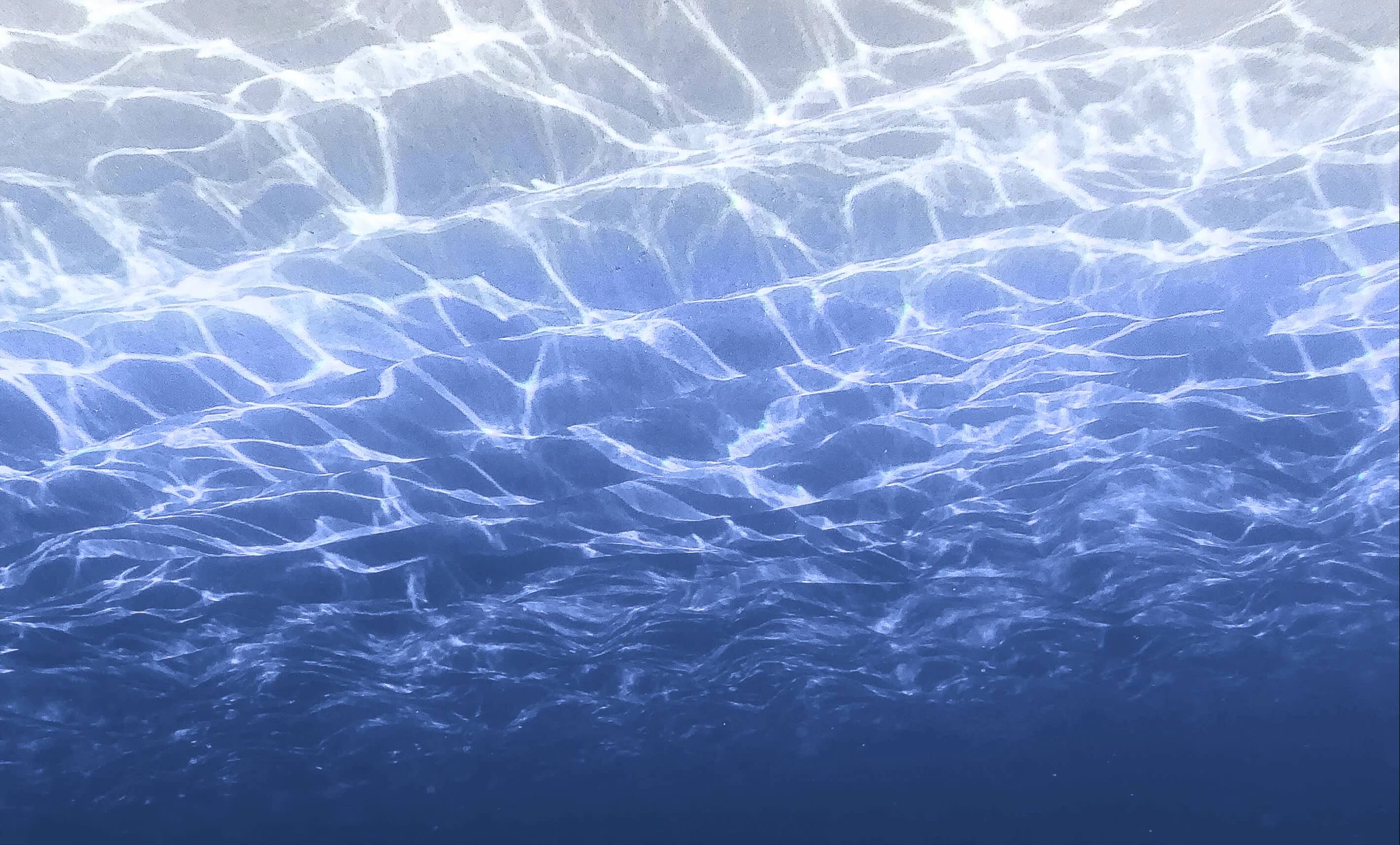 background image of moving water that looks like the sun is shining on it. 
